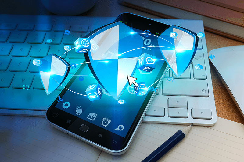 smartphone laying on a keyboard with shields and mobile icons coming out of it