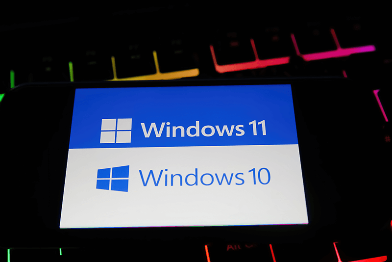 tablet with windows 11 logo on top of windows 10 logo