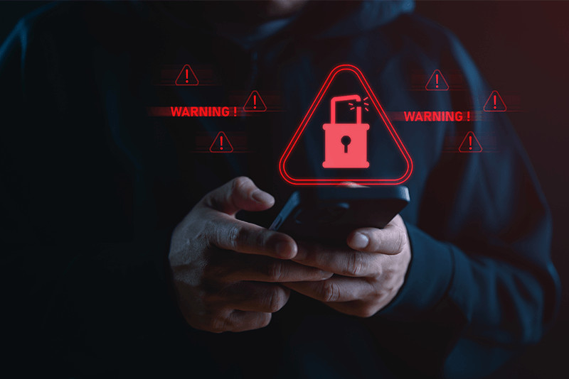 hacker breaking into phone with red warning signs floating around it