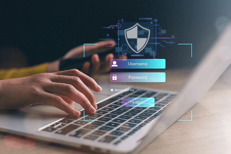 person typing on a laptop with a shield and username and password icons over it