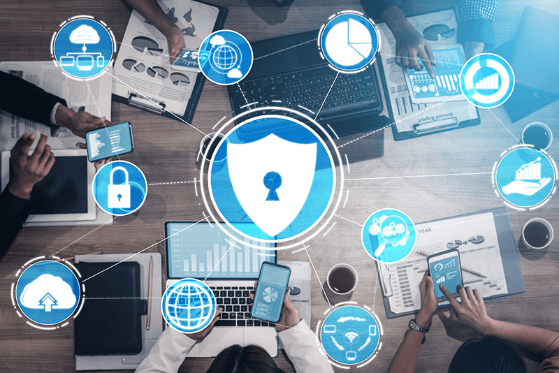 cybersecurity shield surrounded by other technology graphics over a business meeting