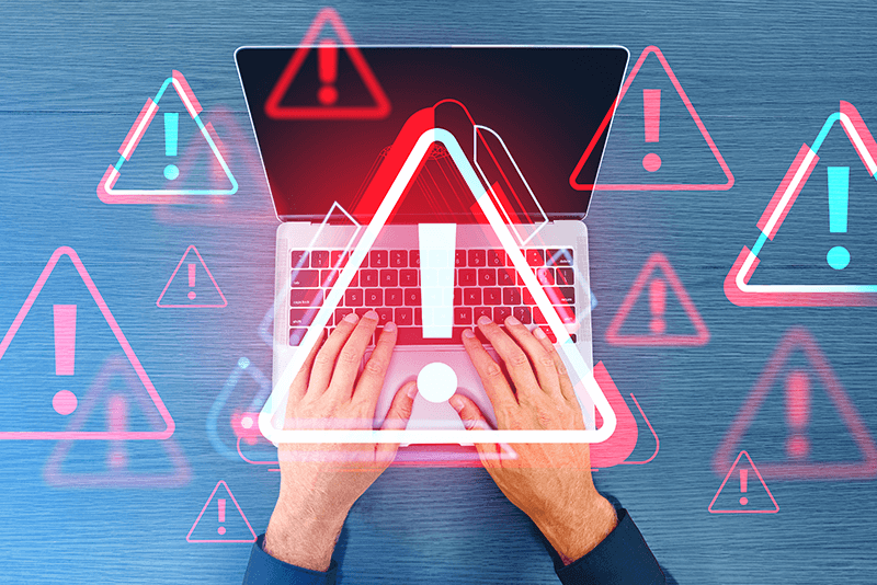 person using laptop with red and blue warning signs hovering over it